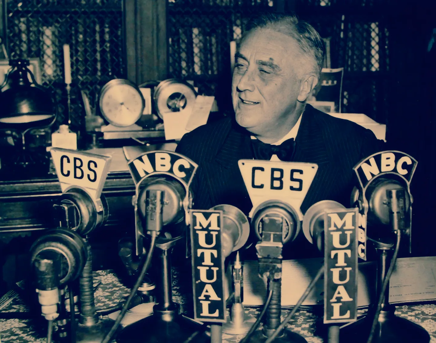 President Franklin D. Roosevelt seated at a microphone for his Election Eve Radio Address to the Nation, November 4, 1938.